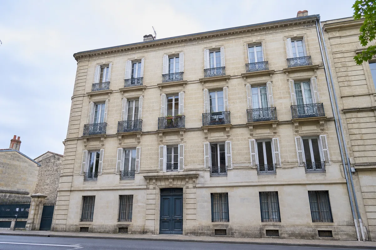Façade d’immeuble d’habitation français vue depuis le trottoir opposé en fin de matinée